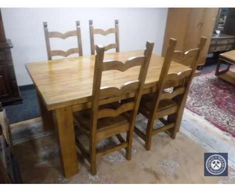 A pine dining table fitted a drawer and four ladder back chairs 