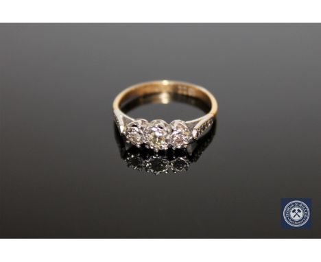 An 18ct gold and platinum set three stone diamond ring, approximately 0.25ct, size K 1/2.