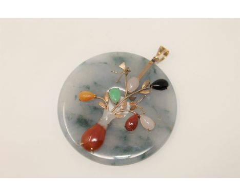 A large jade disc pendant set with various coloured jade mounted in gold