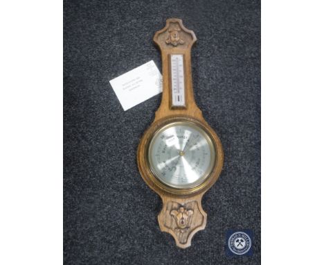 A carved oak cased banjo barometer by Comitti of London 