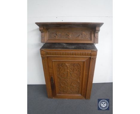 An antique carved oak wall cabinet and a similar wall shelf 