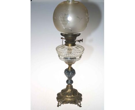 Victorian oil lamp depicting ornate cherub column and etched grape shade.