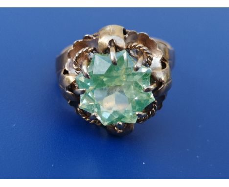 A continental solitaire ring set with a fancy star cut pale green stone - setting tests as 18ct gold.  Finger size J.