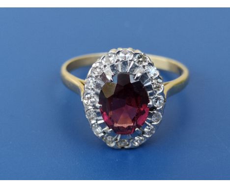 An oval garnet &amp; diamond cluster ring in 18ct &amp; PLAT.  Finger size R/S.