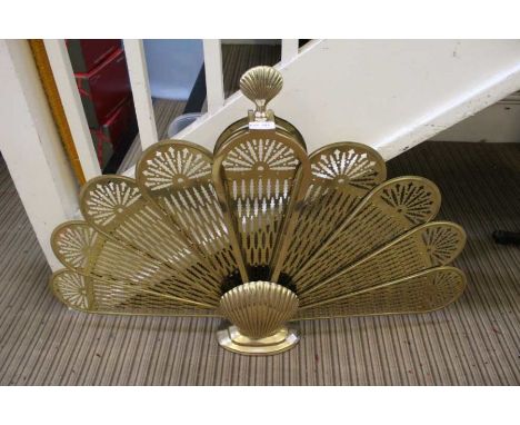 A brass peacock fire screen