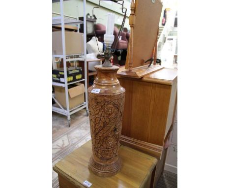 A carved wooden table lamp