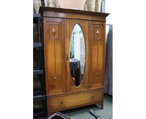 A first quarter 20th century oak wardrobe with applied beaded decoration &amp; a full width shoe drawer