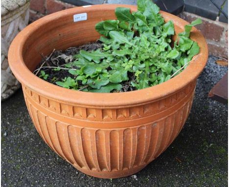 A moulded terracotta circular garden planter