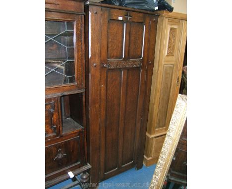 A good 1940's Oak single door Wardrobe, the cruxiform four panel door with carved motif to the top rail and stylised circular