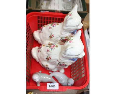 A pair of ceramic Cats with floral decoration and a pair of small grey seal ornaments.