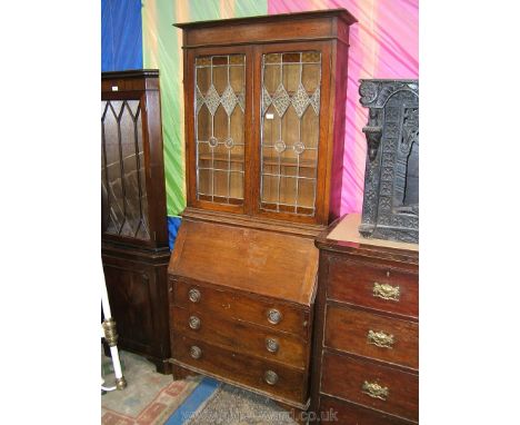 A good arts and crafts Bureau Bookcase, having moulded cornice over pair of opposing leaded, 24 pane glazed doors with orange