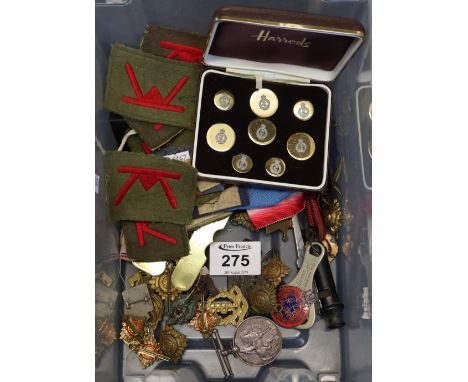 Box of assorted military insignia including fabric badges and flashes, pips, cap badges etc. Together with two brass equipmen