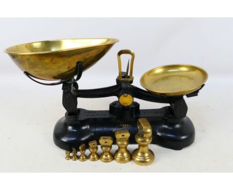 A vintage set of cast iron and brass Libra Scale Co kitchen scales and weights. [W]