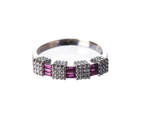 A RUBY AND DIAMOND RING set with alternating baguette-cut rubies and pavé-set brilliant-cut diamond cubes, weighing approxima