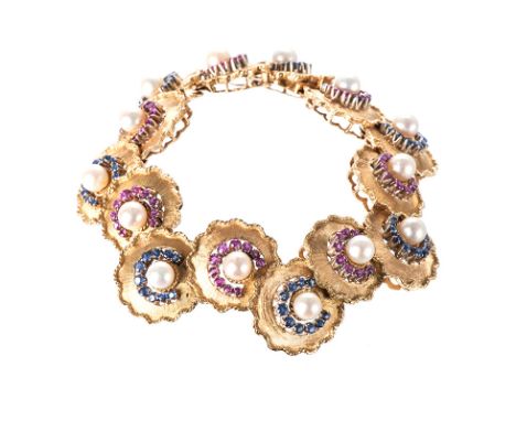 A PEARL, RUBY AND SAPPHIRE BRACELET composed of fourteen flexible, stylised flower links, each of matte finish with rope surr