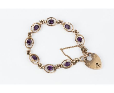 AN AMETHYST SET BRACELET, designed as a line of openwork oval panels centred with mixed-cut amethysts, spaced by gate links, 