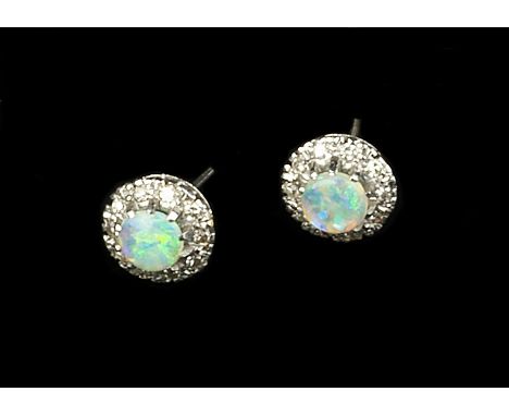 A PAIR OF OPAL AND DIAMOND CLUSTER EAR STUDS, each centred with a circular cabochon opal in claw setting, bordered by single-