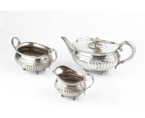 A LATE VICTORIAN SILVER THREE PIECE TEA SERVICE, with gadrooned borders, lobed bodies and foliate handles, on ball feet, the 