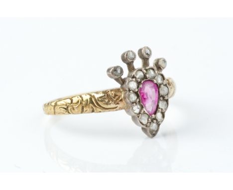 A 19TH CENTURY RUBY AND DIAMOND PANEL RING, modelled as a crowned heart, centred with a pear-shaped ruby bordered by rose-cut
