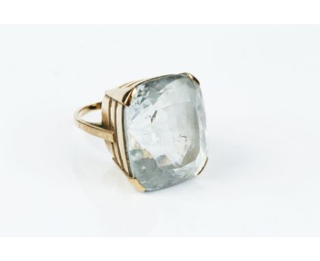 A TOPAZ SINGLE STONE RING, the cushion-shaped mixed-cut topaz of pale whiteish-blue hue, in four claw setting, yellow preciou
