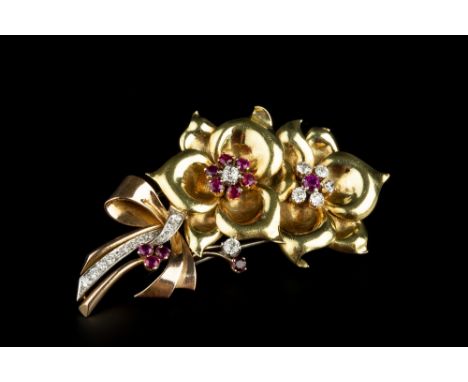 A RUBY AND DIAMOND FLORAL SPRAY BROOCH, circa 1940-45, designed as two stylized flowerheads, each centred with a cluster of c
