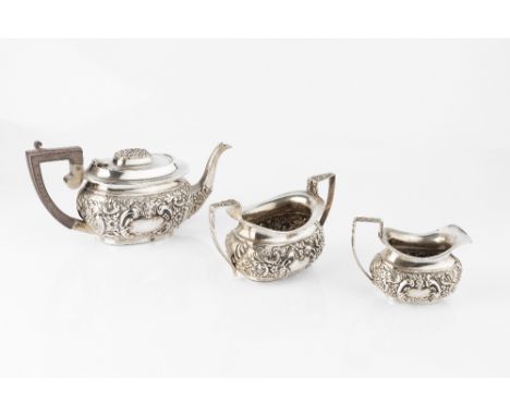 AN EDWARDIAN SILVER THREE PIECE TEA SERVICE, repoussé decorated with flowers and scrolling foliage, by Nathan &amp; Hayes, Ch