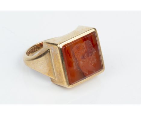 A HARDSTONE INTAGLIO RING, the rectangular cornelian panel incised with two classical male portrait profiles, 9ct gold mounte