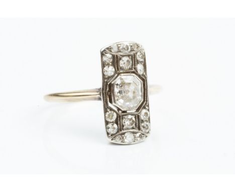 A DIAMOND PANEL RING, the shaped rectangular panel centred with an octagonal step-cut diamond in collet setting, to a pierced