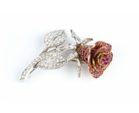 A RUBY AND DIAMOND FLORAL SPRAY BROOCH, naturalistically modelled as a rose flowerhead, with pavé set petals of graduated cir