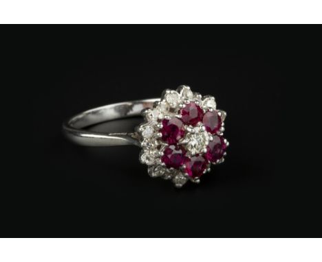 A RUBY AND DIAMOND CLUSTER RING, designed as a target cluster of round brilliant and single-cut diamonds spaced by circular m