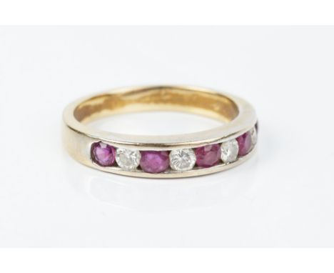 A RUBY AND DIAMOND HALF HOOP RING, channel set with a line of alternate round brilliant-cut diamonds and circular mixed-cut r