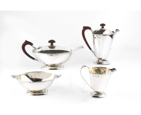 AN ART DECO SILVER FOUR PIECE TEA SERVICE of bowed outline, the teapot and hot water pot with bakelite handles and knops, on 