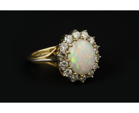 AN OPAL AND DIAMOND CLUSTER RING, the oval cabochon opal in claw setting, bordered by round brilliant-cut diamonds, 18ct two 