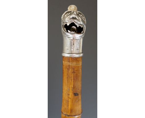 A Mughal flick stick the silver terminal cast as a lion's head its mouth open, the top with hinged compartment revealing flic