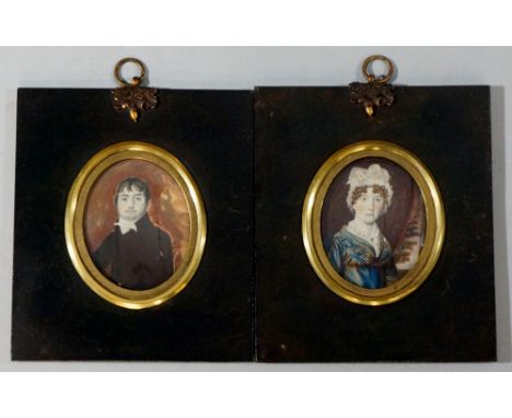 A pair of mid 19th Century portrait miniatures of a husband and wife she wearing lace trimmed bonnet and blue dress he with b