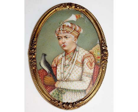 Indian School, 19th Century -oval half length portrait of a Maharaja with bird of prey on his left arm, watercolour on ivory,