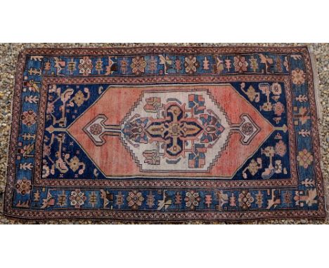A Persian Nahavand, worked with a cream geometric pole medallion on a faded red ground, floral filled blue spandrels, guard s