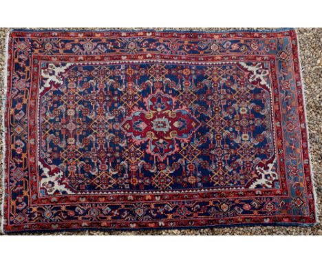 A Persian Malayer rug, worked with central medallion on an indigo blue ground filled with stylised leafage and medallions, gu