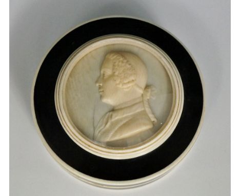 A circular ivory and tortoiseshell snuff box and cover the lid with glazed roundel, relief carved with head and shoulder bust