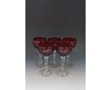 A set of five ruby bowl hock glasses, engraved with grapes and vines, clear stems, each 16cm high, 8cm wide