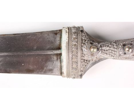 A mid-20th century Middle Eastern silver mounted jambia with typical curved blade with central rib, blade length 32cm, and co