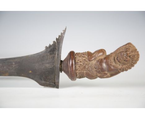 An early 20th century Indonesian kris dagger with straight-form blade, blade length 34.5cm, and wooden handle, carved in the 