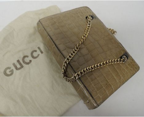 A "Gucci" handbag in light brown crocodile skin effect with leather lining and gilt chain handles, in soft bag printed "Gucci