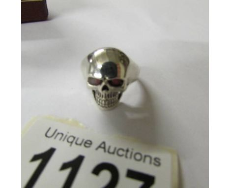 A skull ring with ruby eyes, size R.