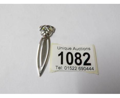 A silver bookmark with dog finial.
