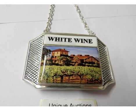 A silver plate and enamel wine bottle label.