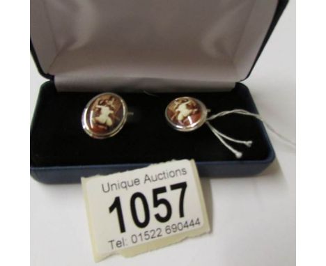 A pair of silver and enamel cuff links with nude figure.