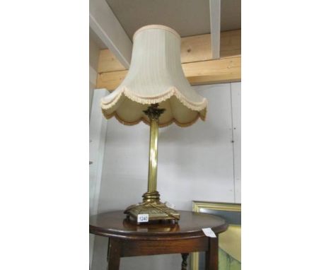 A brass Corinthian column table lamp with shade.
