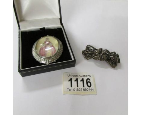 A silver marcasite brooch/dress clip and a hand painted portrait brooch.