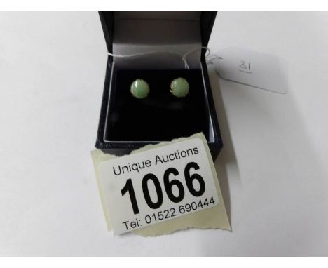A pair of yellow gold and jade stud earrings.